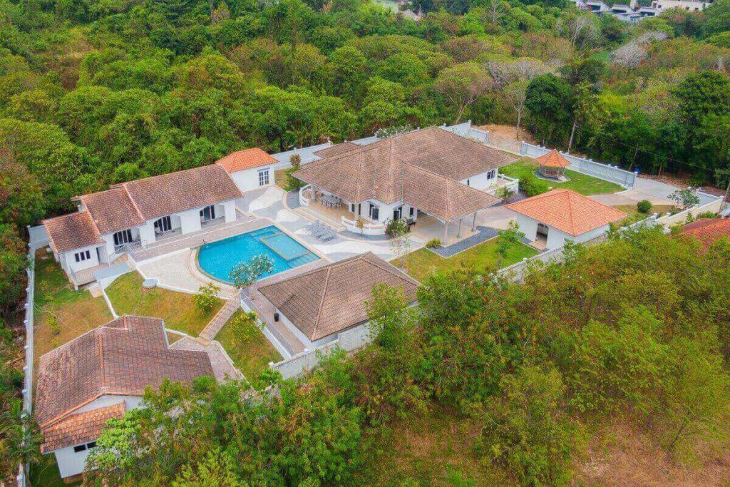 Expansive 10-bedroom villa estate near Nai Harn with multiple buildings, pool, and tropical garden
