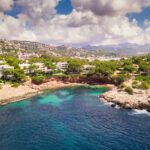 Aerial view of villas on the cliffs above Cala Marmassen Bay in Andratx, Mallorca, with turquoise water and coastal landscape