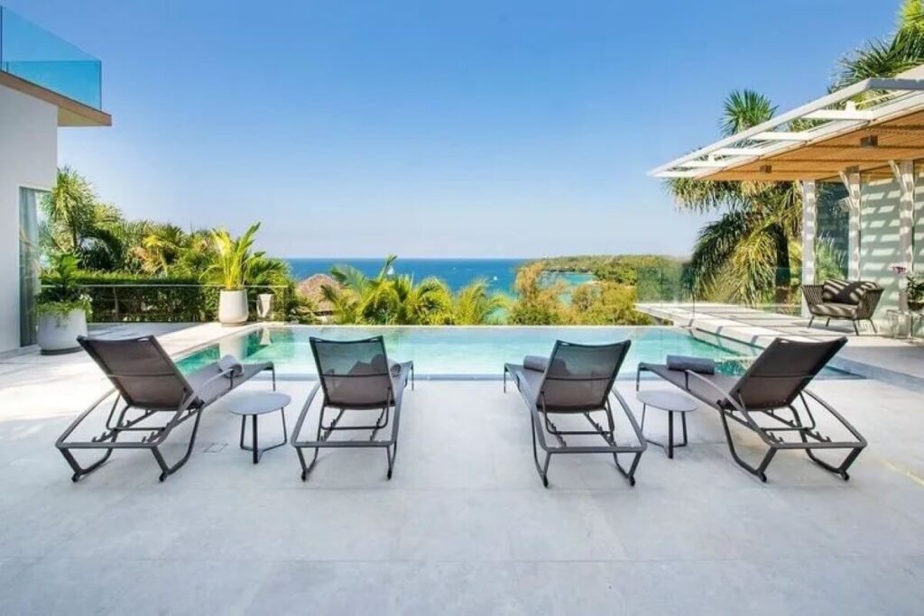 4-Bed Luxury villa for Sale in Surin, Phuket - Build Area 745 sqm Villa for Sale Surin, Phuket, Thailand See map € 2,697,541 4 4 Bedrooms 5 5 Bathrooms 484 sqm Plot Size 745 sqm Built-up Area Villa Property Type REF ID: psv-sur-1627 Property Features Villa / Houses4 bed5 bathAir ConditioningPoolThe Land area is 484 sqmThe built up area is 745 sqmSecure ParkingBalconyDeck Full Description Overview This resale 4-bedroom sea view pool villa in Surin, Phuket enjoys breathtaking views across the Andaman Sea towards the iconic Amanpuri Resort. Tastefully designed, the villa pairs contemporary furnishings with a refined neutral palette accented by soft furnishings, artwork, and decorative pieces. Expansive glazing and open-plan living spaces maximise natural light while framing panoramic ocean views from multiple areas of the home. Offered at US$3.2 million or the equivalent in Thai Baht, this modern contemporary residence is within walking distance of Surin Beach, one of Phuket’s most prestigious west coast locations. Layout The villa is set on a generous 484 sqm plot with a built-up area of 745 sqm arranged across 2 levels. There are 4 spacious bedrooms with ensuite bathrooms, 2 on the main level and 2 on the upper floor. Key features include a 10-metre infinity pool, a massage room, and a large viewing deck overlooking the coastline and the Andaman Sea. Development Overview Developed by a private luxury villa developer responsible for 2 other premier residential developments in Phuket. The estate is an exclusive hillside collection of just 9 luxury sea view villas with 3-11 bedrooms. Location Located on a hillside directly across the road from Surin Beach, the villa is within a 450-metre walk to the beach. Within a 5 to 15 minute drive are Cafe del Mar, Boat Avenue, Laguna, upscale dining venues, beach clubs, and a wide range of lifestyle amenities. Patong is 23 minutes away, while Phuket International Airport is around 20 km or approximately a 45 minute drive. For a broader look at the area, view Surin property for sale. You may also want to explore Surin villas for sale. Property Features * Villa / Houses * 4 bed * 5 bath * Air Conditioning * Pool * 484 sqm * 745 sqm * Secure Parking * Balcony * Deck * Outdoor Entertaining * Freehold (Thai Company) * Fully Furnished * Gated Community * Large Pool * Massage Room / Facilities * Near Beach * Private Pool * Resale * Sea View * Seafront / Seaside