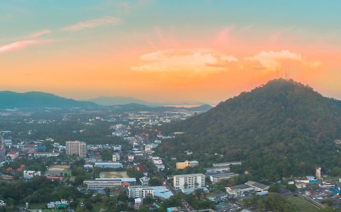 View of Phuket and surrounding hills at sunset, showing urban development and natural landscape