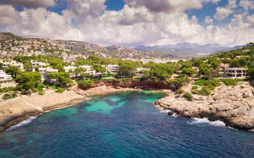 Aerial view of villas on the cliffs above Cala Marmassen Bay in Andratx, Mallorca, with turquoise water and coastal landscape